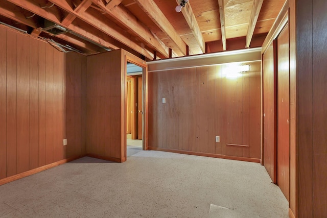 below grade area featuring wooden walls and baseboards