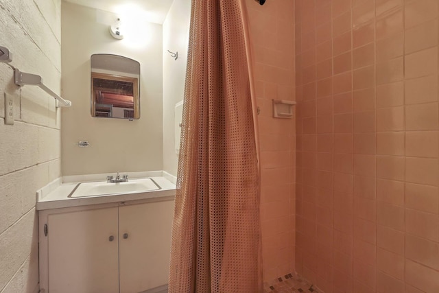 bathroom featuring a tile shower and vanity