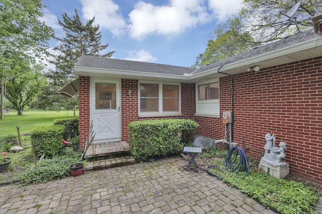 entrance to property featuring brick siding