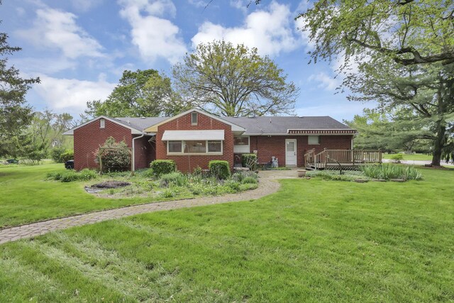 single story home featuring a deck, brick siding, and a front lawn