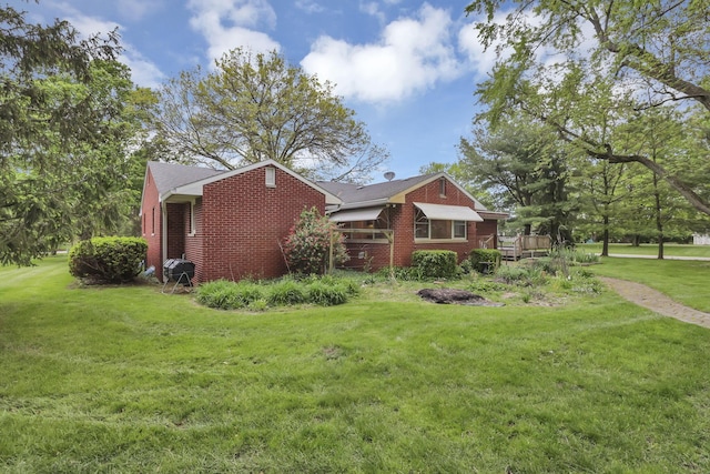 view of property exterior featuring brick siding and a yard