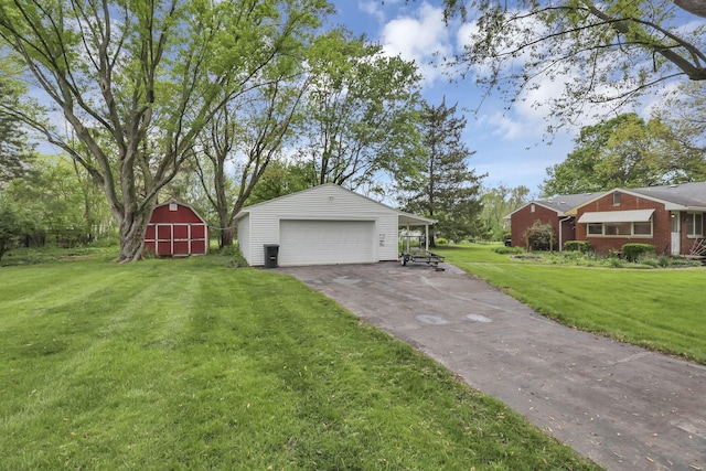 view of grassy yard featuring an outbuilding and a detached garage