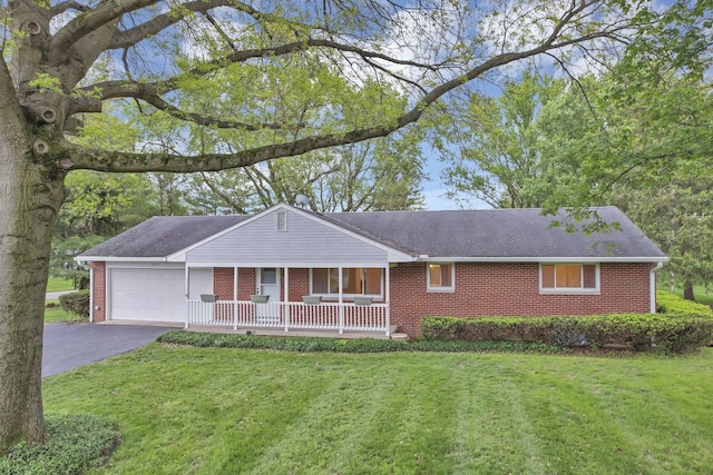 ranch-style home featuring a garage, a porch, brick siding, driveway, and a front yard