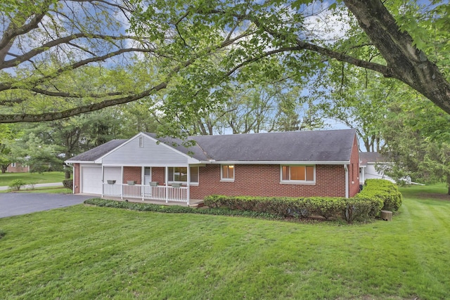ranch-style house featuring brick siding, driveway, a garage, and a front yard