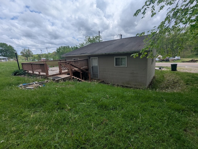 rear view of house with a wooden deck and a lawn