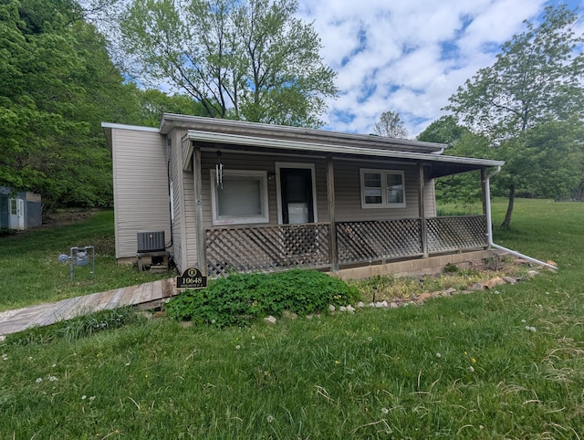 bungalow featuring a porch, central air condition unit, and a front yard