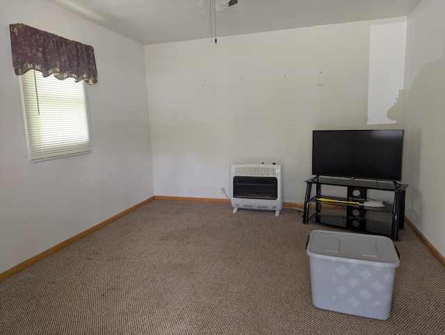 unfurnished living room featuring baseboards, carpet flooring, heating unit, and a ceiling fan