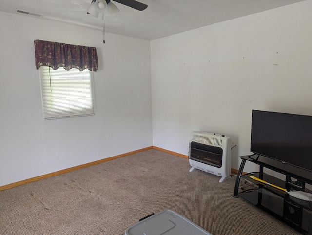 interior space featuring heating unit, carpet floors, visible vents, baseboards, and ceiling fan