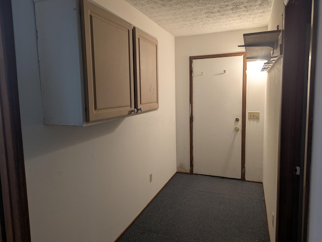 corridor with carpet and a textured ceiling
