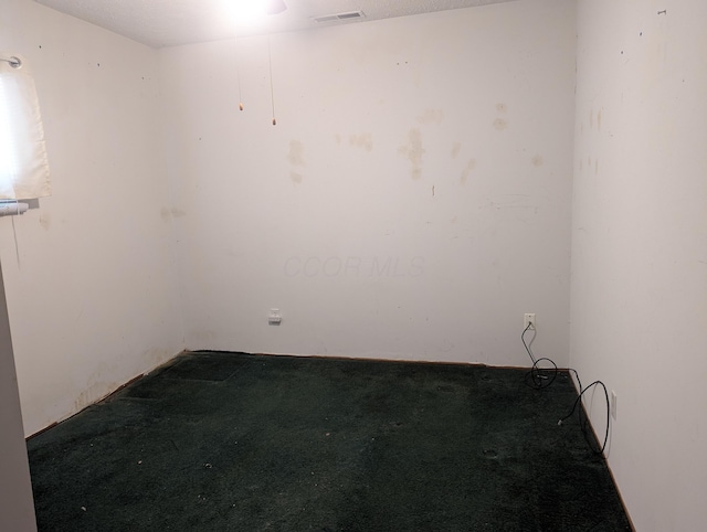 spare room featuring carpet flooring and visible vents