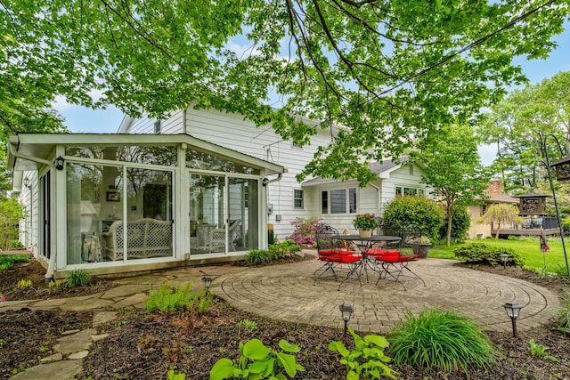 rear view of house featuring a sunroom and a patio area