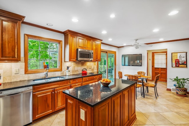 kitchen with stainless steel appliances, a sink, ornamental molding, light tile patterned floors, and tasteful backsplash