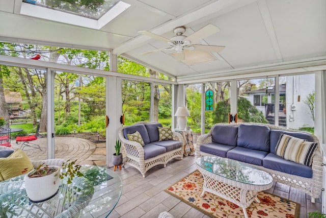 sunroom / solarium with an outdoor living space, ceiling fan, wood finished floors, and a skylight