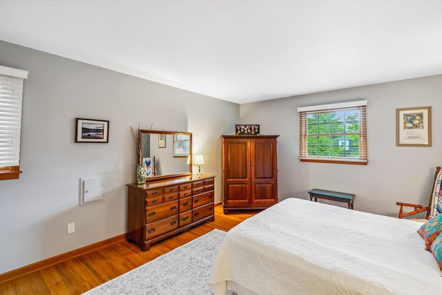 bedroom featuring wood finished floors and baseboards