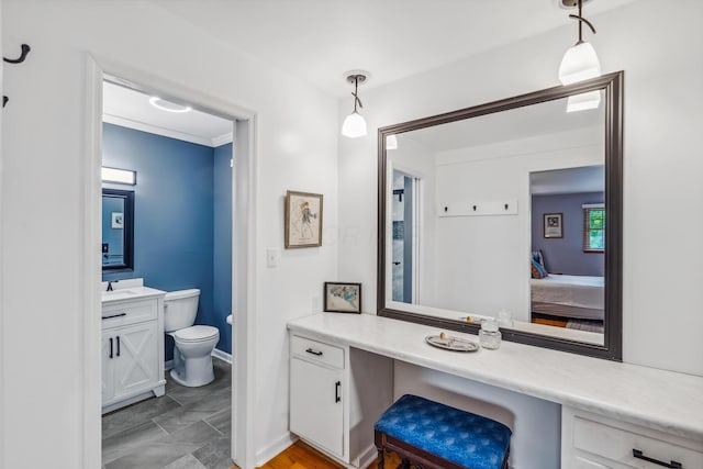 bathroom with vanity, toilet, ensuite bath, and baseboards