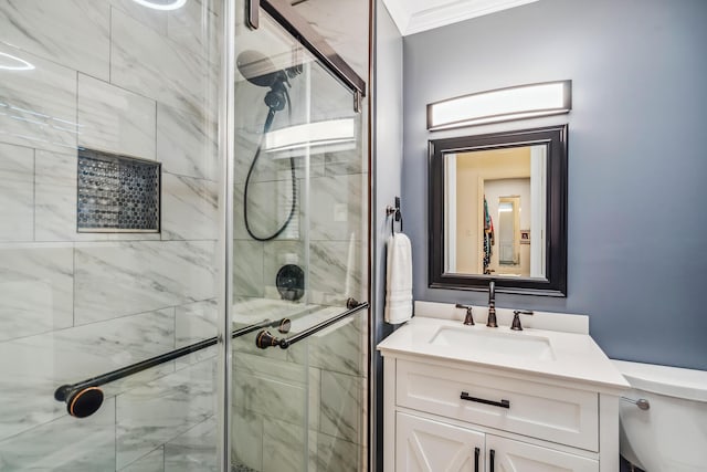 bathroom featuring a shower stall, vanity, toilet, and ornamental molding