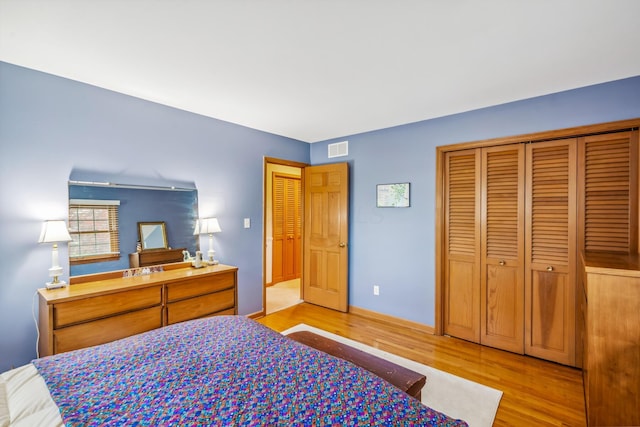 bedroom with light wood finished floors and a closet