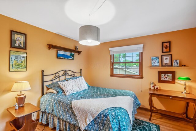 bedroom featuring wood finished floors and baseboards