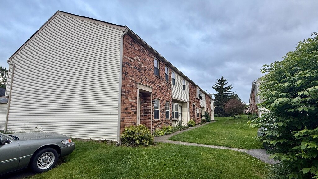 1721 Worthington Run Dr Unit 1721-1731, Columbus, OH 43235 - view of property exterior featuring brick siding and a lawn
