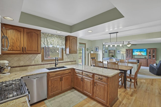 7689 Godfrey Cir, Reynoldsburg, OH 43068 - kitchen with appliances with stainless steel finishes, light wood-style flooring, brown cabinetry, backsplash, and recessed lighting