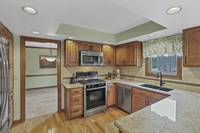 7689 Godfrey Cir, Reynoldsburg, OH 43068 - kitchen featuring appliances with stainless steel finishes, light stone countertops, brown cabinetry, light wood finished floors, and recessed lighting