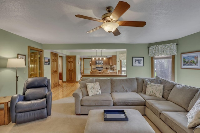 7689 Godfrey Cir, Reynoldsburg, OH 43068 - living area with a textured ceiling, ceiling fan, and light wood-style floors