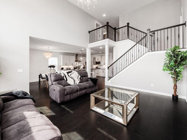 757 Avebury Dr, Pickerington, OH 43147 - living room featuring a chandelier, dark wood-style floors, a high ceiling, ornate columns, and stairway