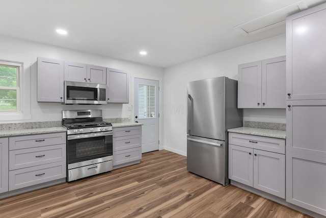 404 Stella Ave, Circleville, OH 43113 - kitchen featuring stainless steel appliances, light wood-type flooring, recessed lighting, gray cabinets, and light stone counters