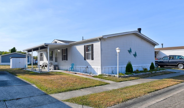 2011 Bluffstone Ct, Grove City, OH 43123 - manufactured / mobile home featuring covered porch, a storage shed, a front lawn, and an outbuilding
