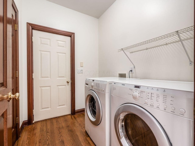 laundry area featuring washing machine and dryer, dark wood-style flooring, baseboards, and laundry area