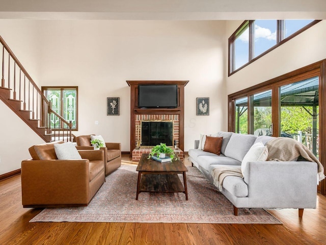 living room with a healthy amount of sunlight, wood finished floors, and a high ceiling