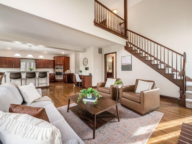 living room featuring visible vents, recessed lighting, stairway, dark wood-style flooring, and a high ceiling