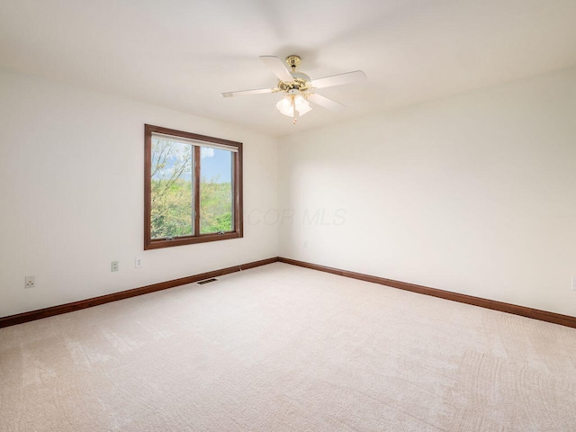 empty room featuring visible vents, baseboards, ceiling fan, and light carpet