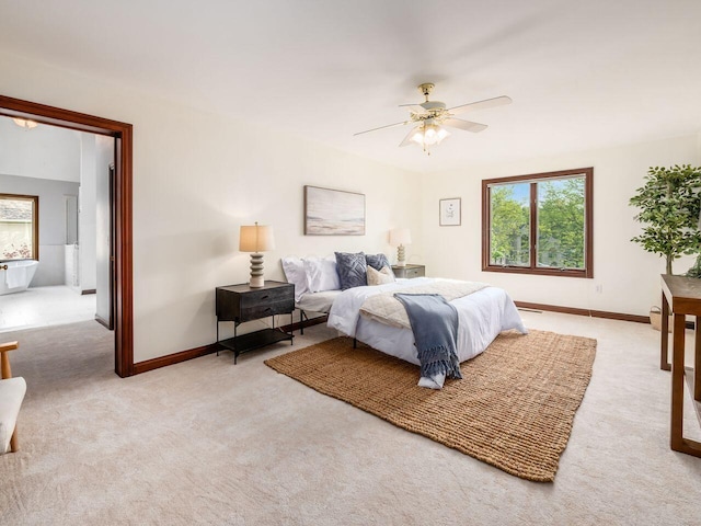 bedroom with multiple windows, light carpet, and baseboards