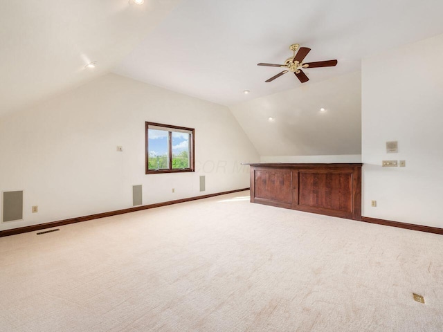 additional living space with visible vents, lofted ceiling, ceiling fan, and light carpet