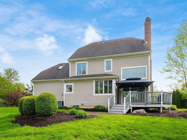 rear view of house with a yard, a gazebo, a wooden deck, and a chimney