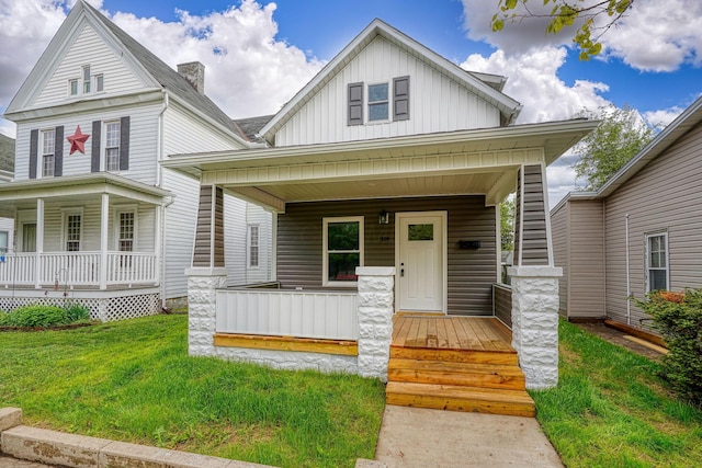 324 E Mound St, Circleville, OH 43113 - view of front of property with covered porch, board and batten siding, and a front lawn