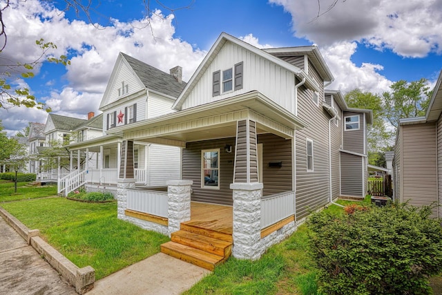 324 E Mound St, Circleville, OH 43113 - view of front of property with a porch, a front yard, and board and batten siding