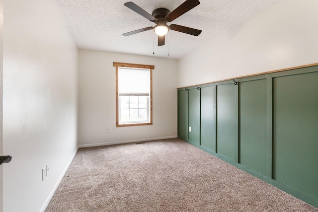 unfurnished bedroom with a textured ceiling, baseboards, a ceiling fan, and carpet floors