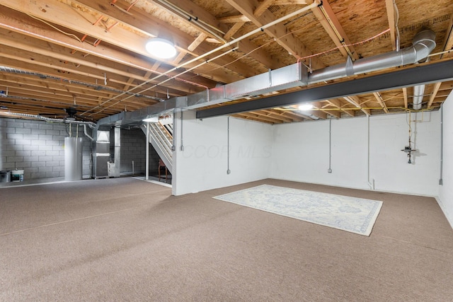 unfinished below grade area featuring stairway, heating unit, carpet, and water heater