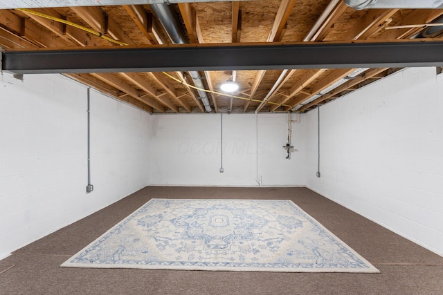 unfinished basement featuring dark carpet