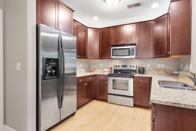 942 Perry St, Columbus, OH 43215 - kitchen featuring stainless steel appliances, a sink, light wood-style floors, light stone counters, and recessed lighting
