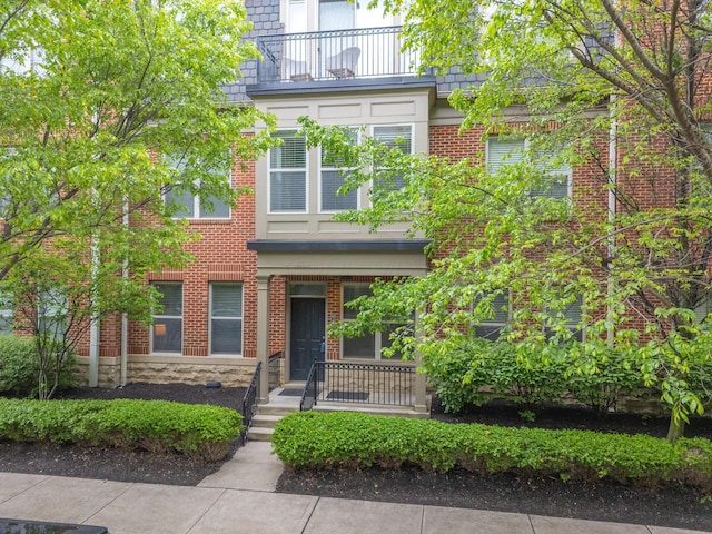 942 Perry St, Columbus, OH 43215 - view of property featuring a balcony, brick siding, and stone siding