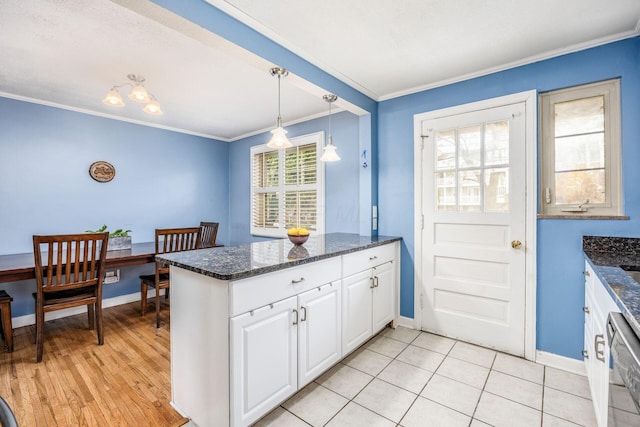 kitchen featuring a peninsula, dishwasher, crown molding, white cabinets, and baseboards