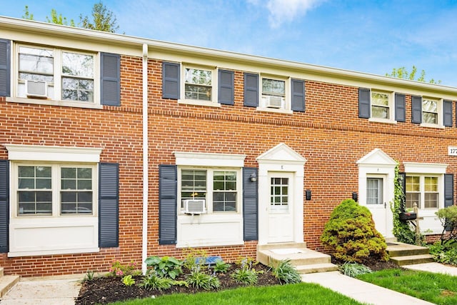 view of property with cooling unit and brick siding