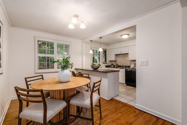1775 NW Ct Unit 109, Columbus, OH 43212 - dining area with light wood-style floors, baseboards, ornamental molding, and a chandelier