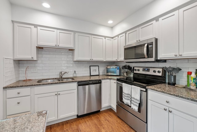 4216 Chaucer Ln, Columbus, OH 43220 - kitchen with stainless steel appliances, tasteful backsplash, a sink, and dark stone counters
