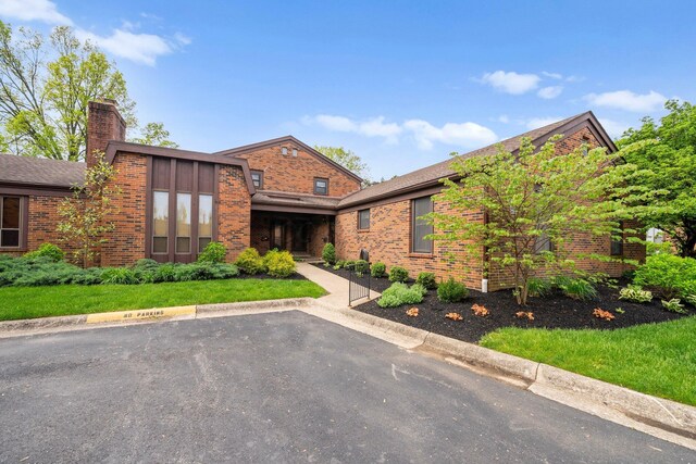 4216 Chaucer Ln, Columbus, OH 43220 - view of front of property with uncovered parking, a chimney, and brick siding
