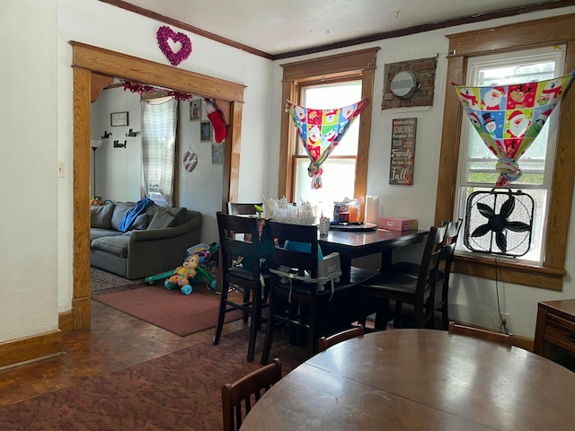 dining space featuring crown molding, baseboards, and wood finished floors