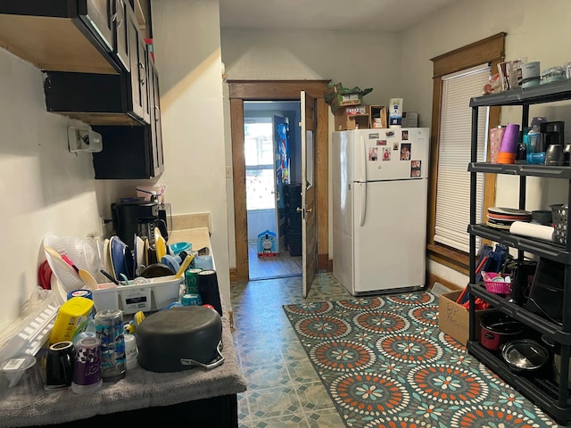 kitchen featuring freestanding refrigerator and tile patterned floors